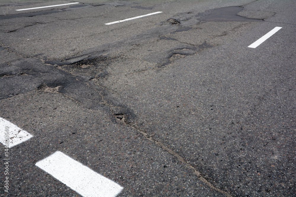 Poor quality of road repair work. Damaged asphalt road, bad road. Poor quality of road repair work. Damaged asphalt road, bad road.