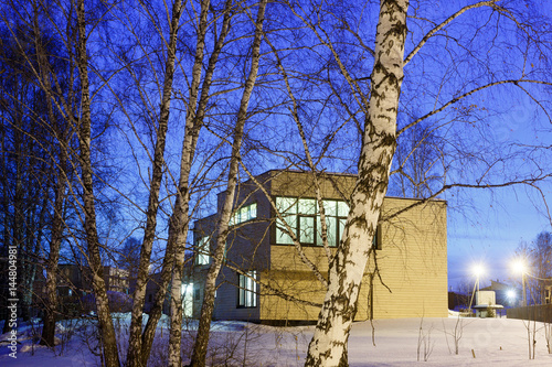 Wooden cottage at night in winter