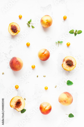 Fresh peaches. Sliced peaches and physalis on white background. Flat lay, top view