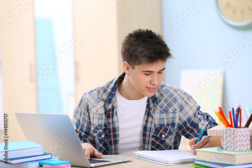 Teenager using laptop and t...