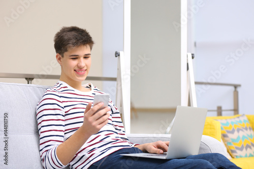 Teenager using laptop and m...