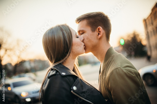 Couple has fun and laughs. kiss. Young hipster couple hugging each other in city.