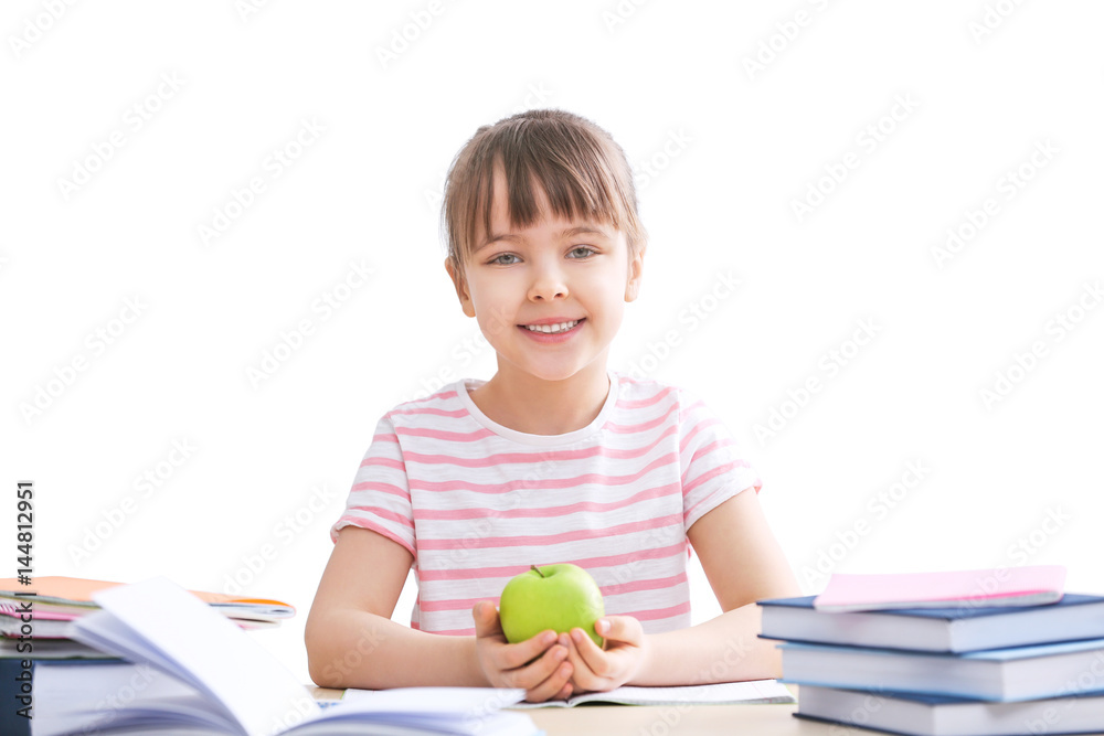 Happy schoolgirl studying at table on white background Happy schoolgirl studying at table on white background