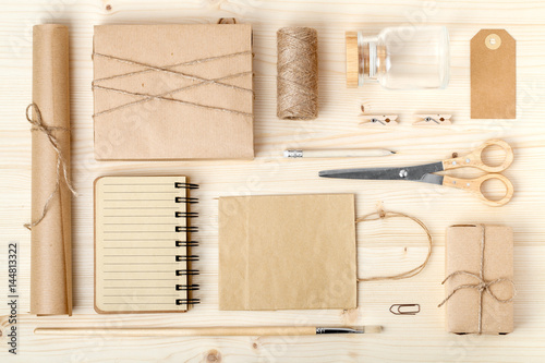 retro branding for mock up template design.vintage wrapped gift boxes, paper bag, postcard, notebook and wrapping tools on wooden background. mail and handicraft concept. above view. flat lay