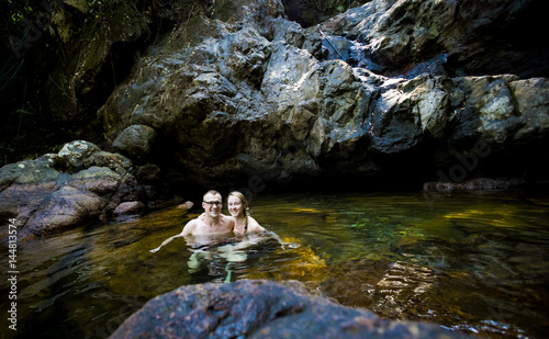 Beautiful couple swimming in waterfall