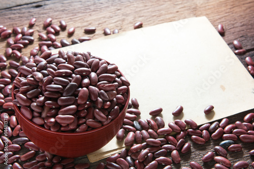 Red beans in a cup with a wooden sign on the wooden floor.