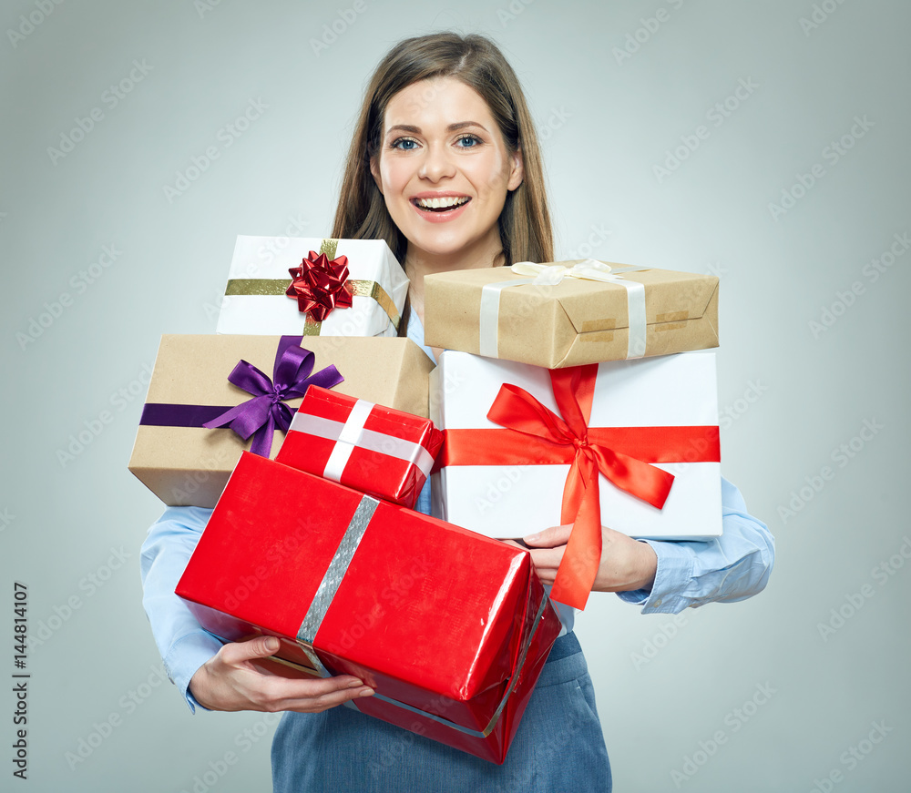Smiling young woman holding pile of gifts. Smiling young woman holding pile of gifts.