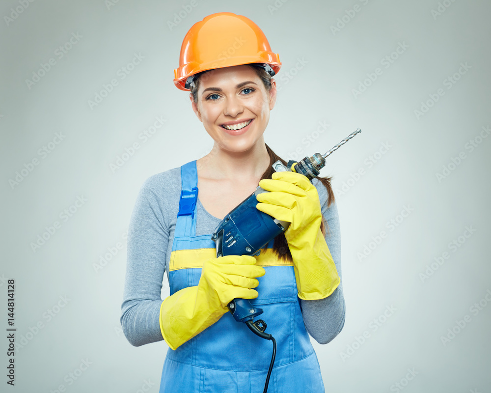 Smiling woman wearing helmet holding drill tool. Smiling woman wearing helmet holding drill tool.