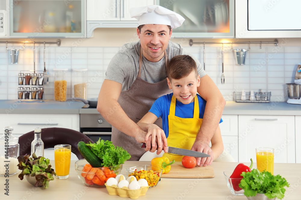 Father and son cooking together in kitchen Father and son cooking together in kitchen