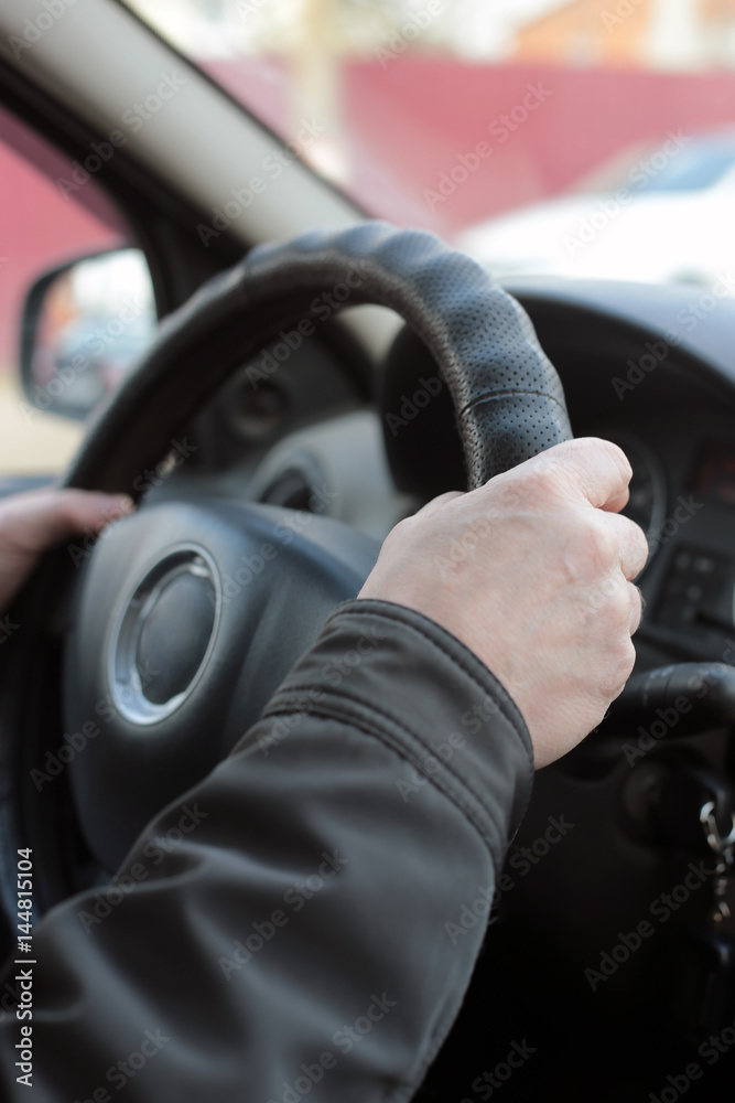 Hands of a man holding a steering wheel