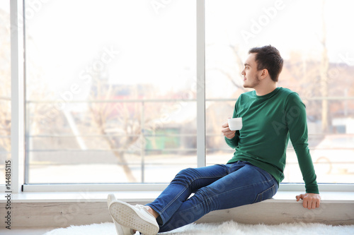 Happy young man with cup of...