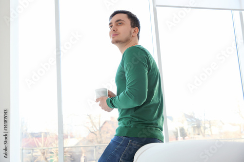 Happy young man with cup of...