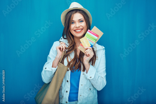 Smiling woman traveler holding passport with ticket. photo