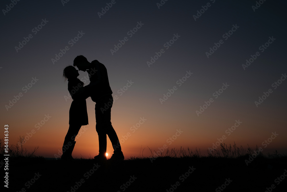 Silhouette of couple in love at sunset