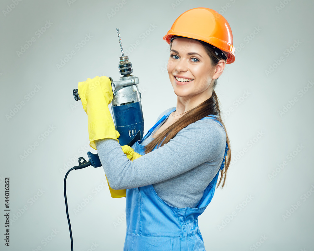 Woman builder holding drill tool.