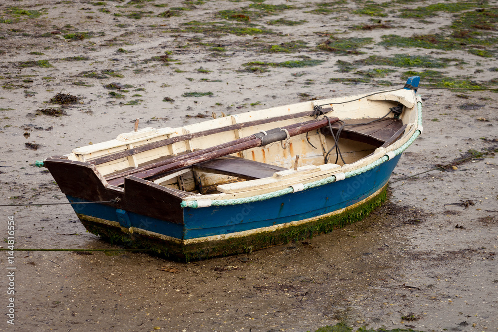 Little fishing boat stranded on the wet sand