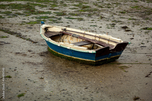 Little fishing boat stranded on the wet sand