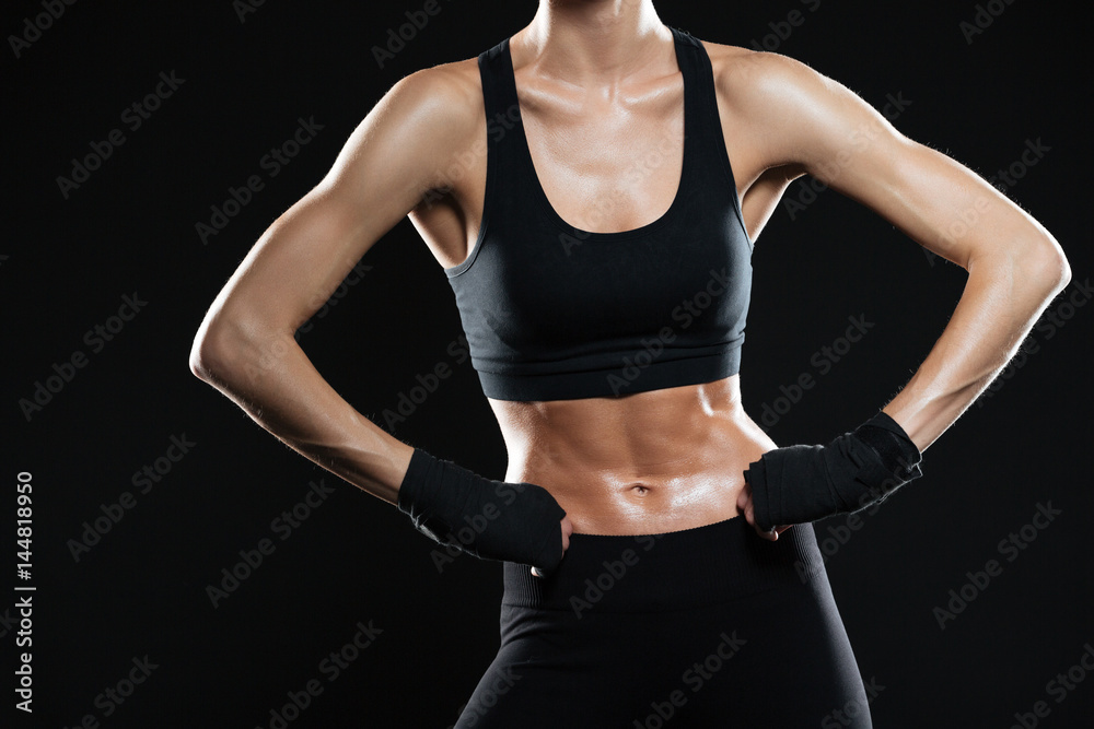 Cropped image of female fighter holding arms on hips Cropped image of female fighter holding arms on hips