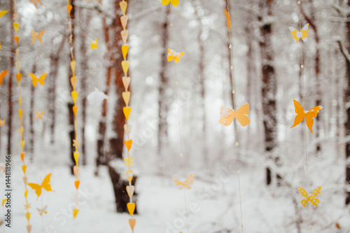 garland of paper butterflies. Against the background of a snow-covered forest.