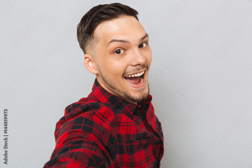Happy man standing sideways and looking at camera Happy man standing sideways and looking at camera