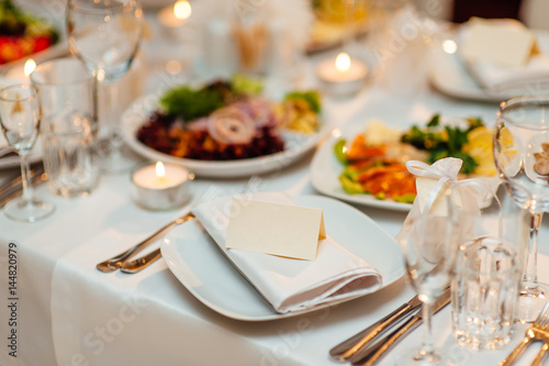 Table setting at a wedding banquet. Decoration flowers. A close-up of a plate with cutlery.