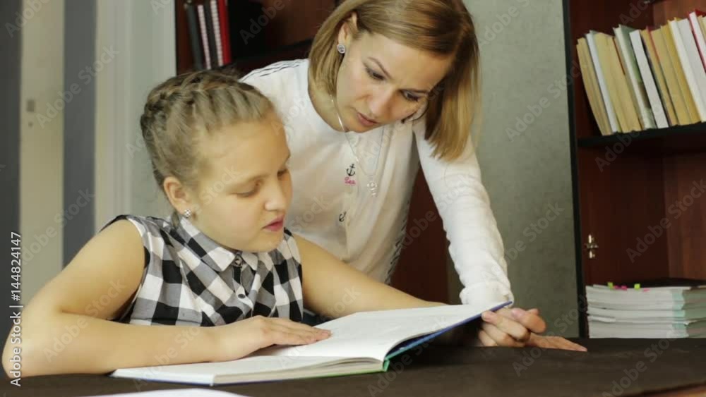 Upset little girl doing school tasks with mother, mom compels daughter to reads Upset little girl doing school tasks with mother, mom compels daughter to reads
