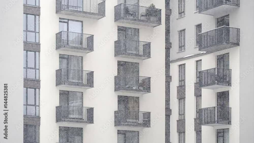 snowing in the yard of modern new building with balconies snowing in the yard of modern new building with balconies