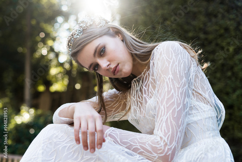 Tender female in bridal dress posing
