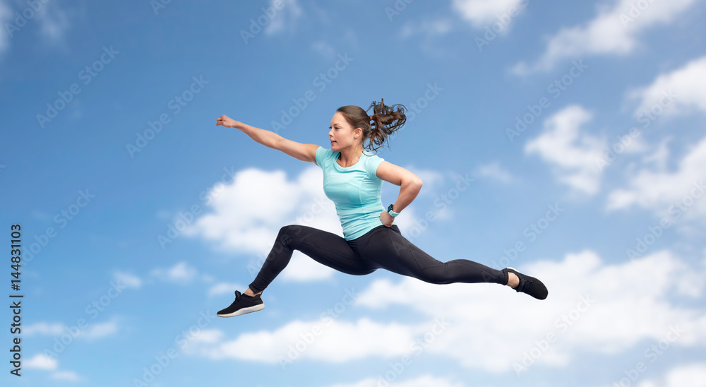 happy sporty young woman jumping in fighting pose