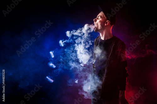 Fototapeta Naklejka Na Ścianę i Meble -  man smoking e-cigarette wearing sunglasses