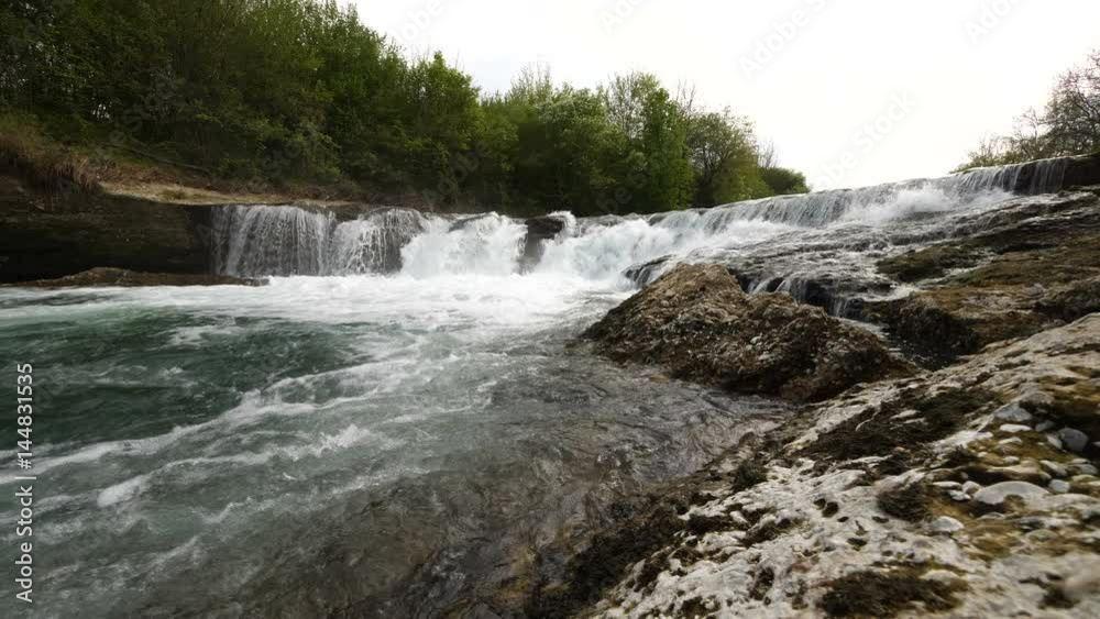 Wide shot of slow motion water floating down a cascade of a river, in 4K Wide shot of slow motion water floating down a cascade of a river, in 4K