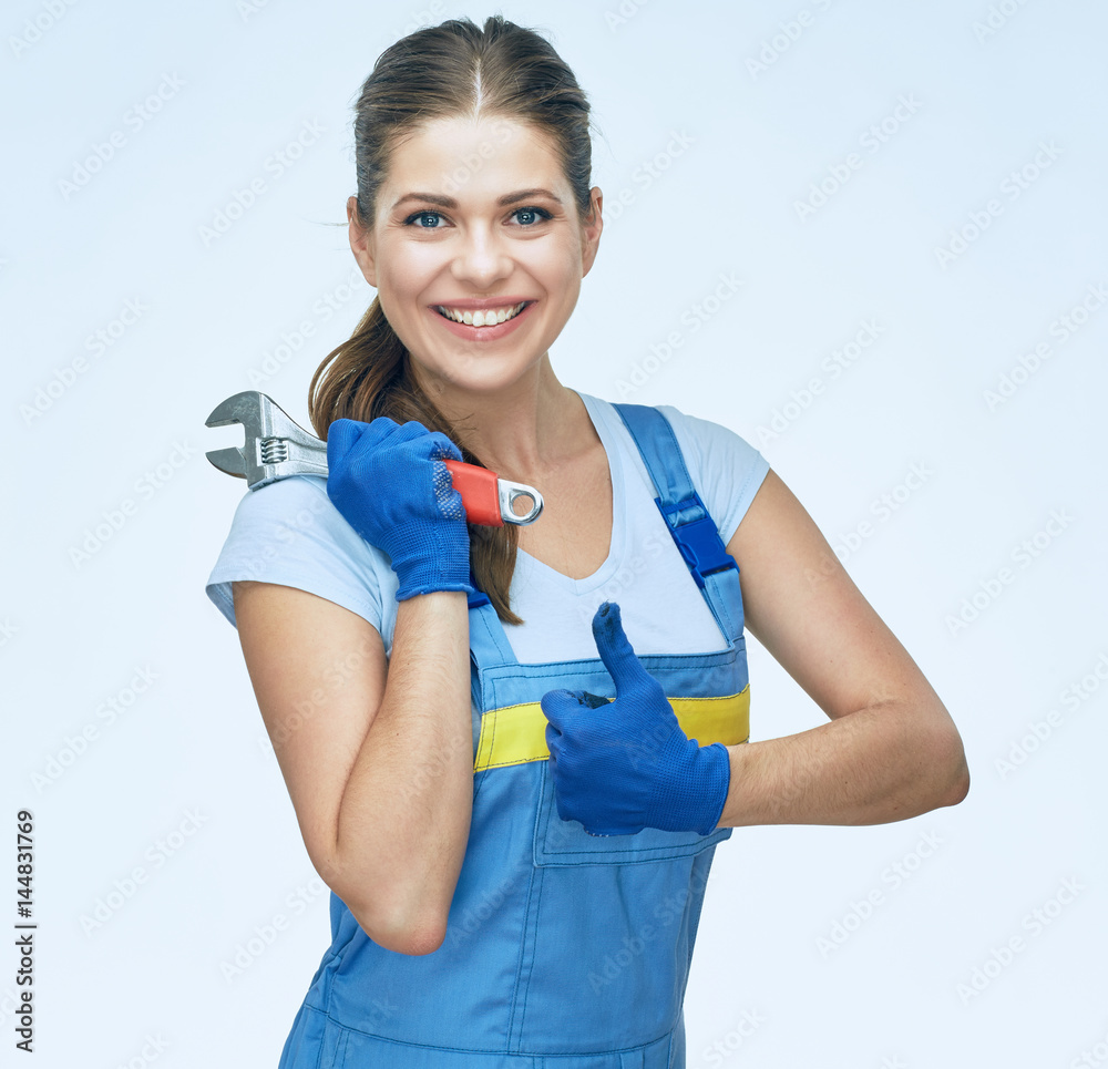 Smiling Woman builder holding wrench and showing thumb up. Smiling Woman builder holding wrench and showing thumb up.
