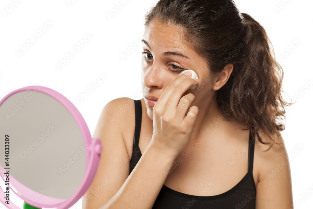 young woman cleans her face using tonic and cotton pads young woman cleans her face using tonic and cotton pads