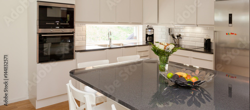 horizontal banner of a fancy kitchen with a kitchen island  in the foreground photo
