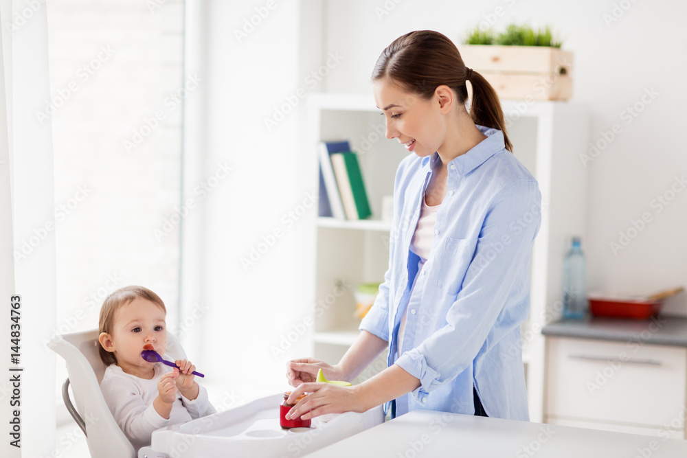 mother and baby with spoon eating puree at home mother and baby with spoon eating puree at home