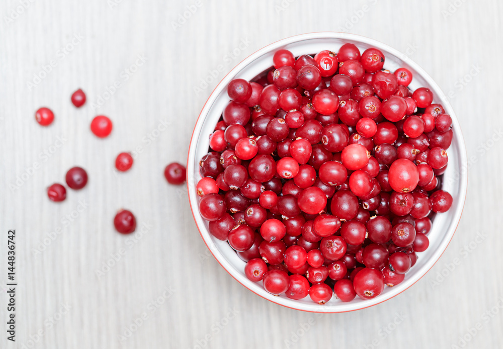 bowl of cowberries on old wooden table bowl of cowberries on old wooden table