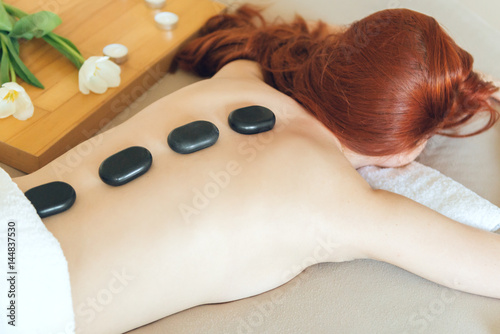 Woman enjoying hot stone massage.