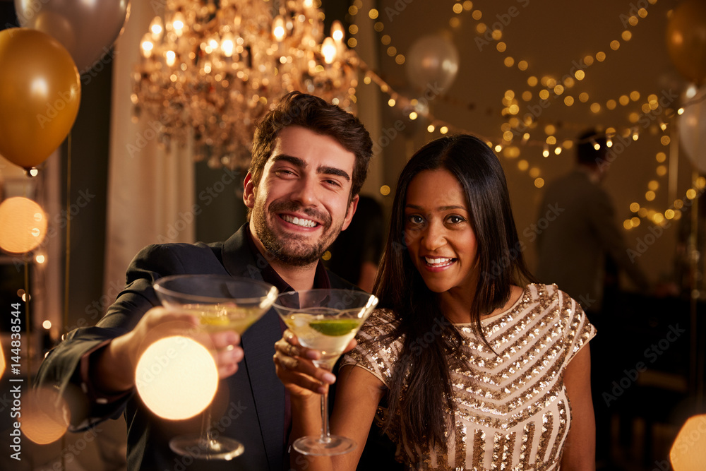 Couple Make Toast At Camera As They Celebrate At Party Couple Make Toast At Camera As They Celebrate At Party