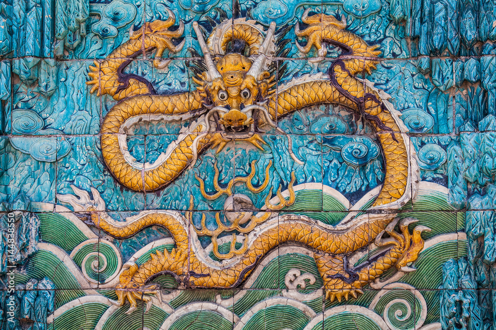 Obraz premium Yellow dragon with raised forepaws on the wall
