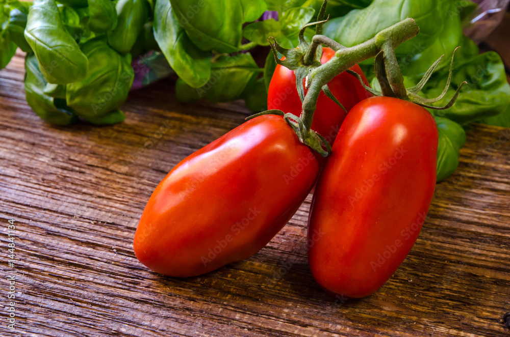 Pomodoro san marzano su tavola con basilico Pomodoro san marzano su tavola con basilico