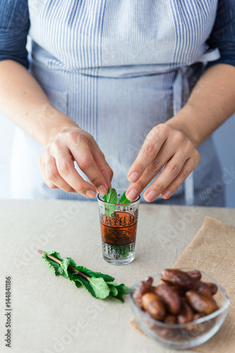 Crop cook putting leaves in small glass