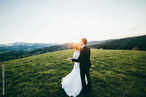 Wedding couple are looking to the sunset