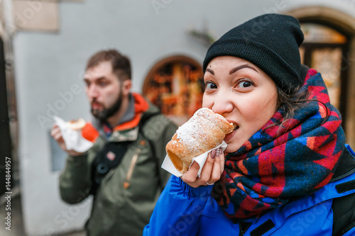 Photography A woman with an appetite eats a traditional Czech sweet pastry called Trdelnik o