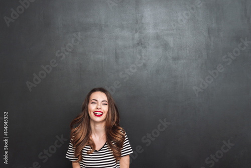 Laughing woman posing in studio and looking at camera