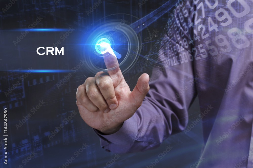 Business, Technology, Internet and network concept. Young businessman working on a virtual screen of the future and sees the inscription: CRM Business, Technology, Internet and network concept. Young businessman working on a virtual screen of the future and sees the inscription: CRM