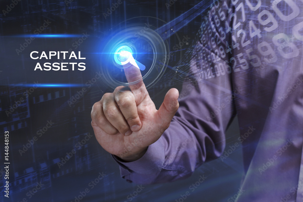 Business, Technology, Internet and network concept. Young businessman working on a virtual screen of the future and sees the inscription: Capital assets Business, Technology, Internet and network concept. Young businessman working on a virtual screen of the future and sees the inscription: Capital assets