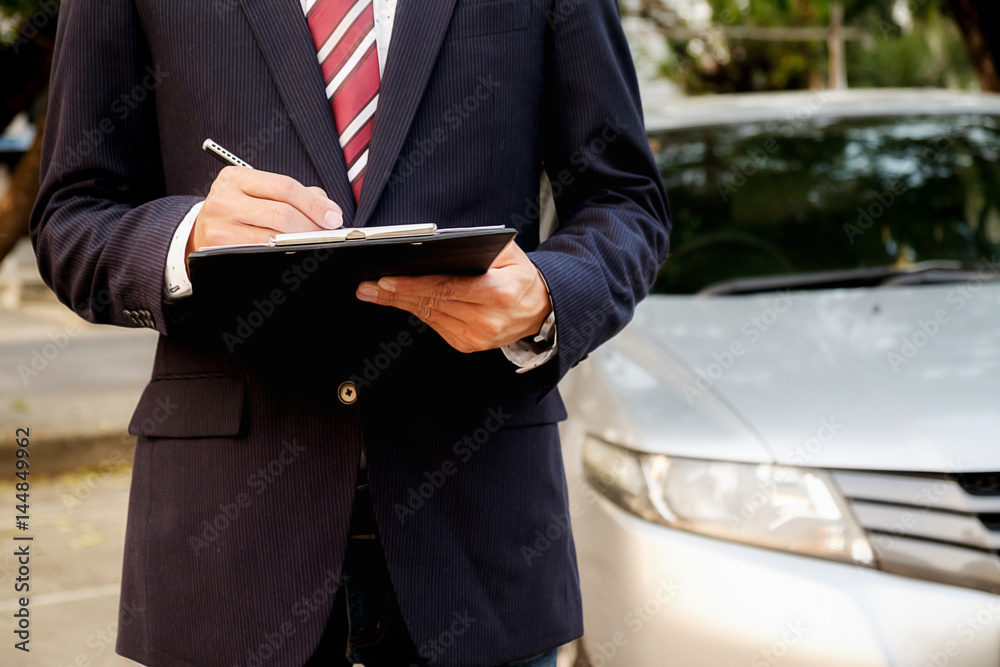 Focusing on work. Handsome young businessman working on his laptop and talking on the phone while sitting on the back seat of the car Focusing on work. Handsome young businessman working on his laptop and talking on the phone while sitting on the back seat of the car