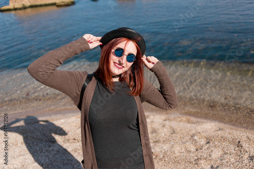 Girl on the beach with a hat and glasses photo