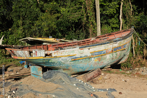 Abandoned stranded fishing boat at the edge of the beach