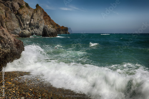 Rocky seashore and waves on a sunny day
